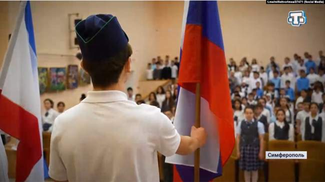 Children in the assembly hall of Simferopol's school No. 44 performing the Russian anthem. Photo: Krym.Realii